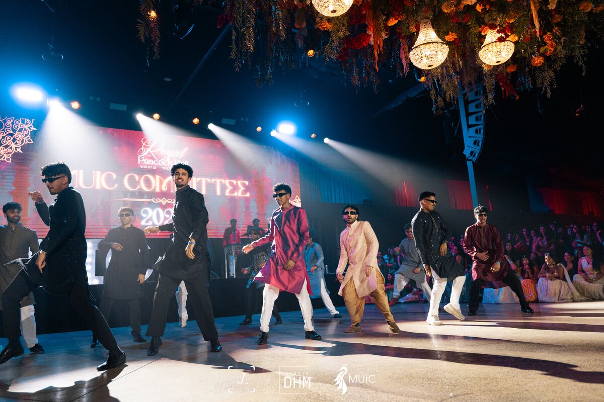 The MUIC committee performing on stage in white