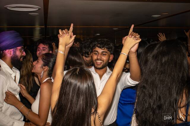 Friends pointing at the skyline from a boat party