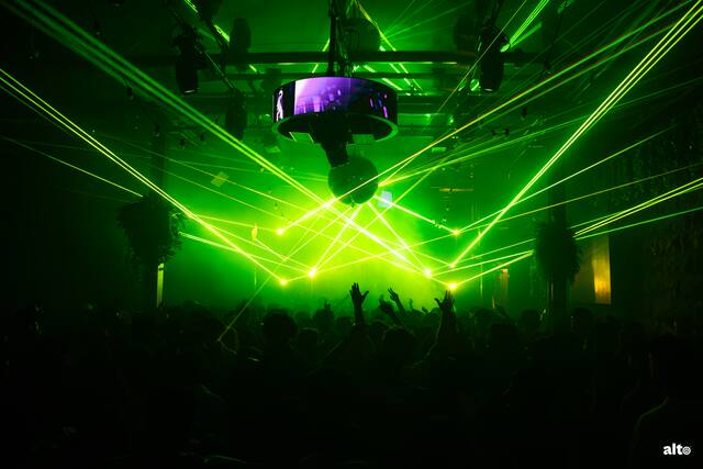 Green lasers over a packed dance floor