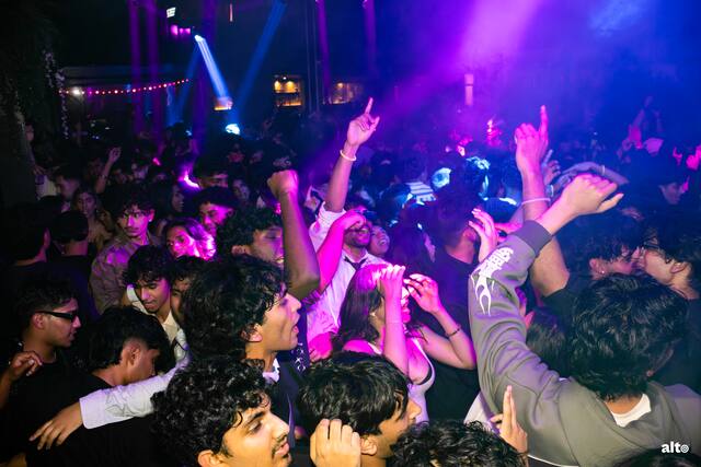 Pink-lit crowd at a club takeover